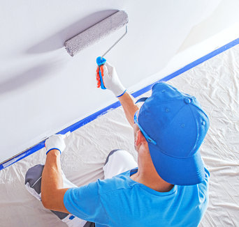 man is painting white color on the wall