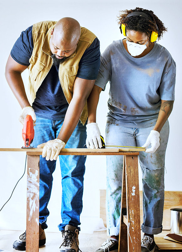 two couple are helping together to build a house