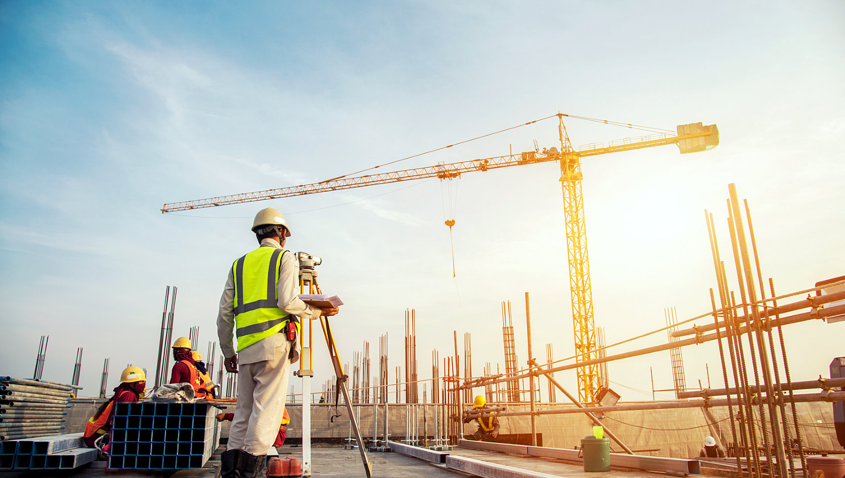 one of construction worker measuring the distance of the building while the other are busy to work