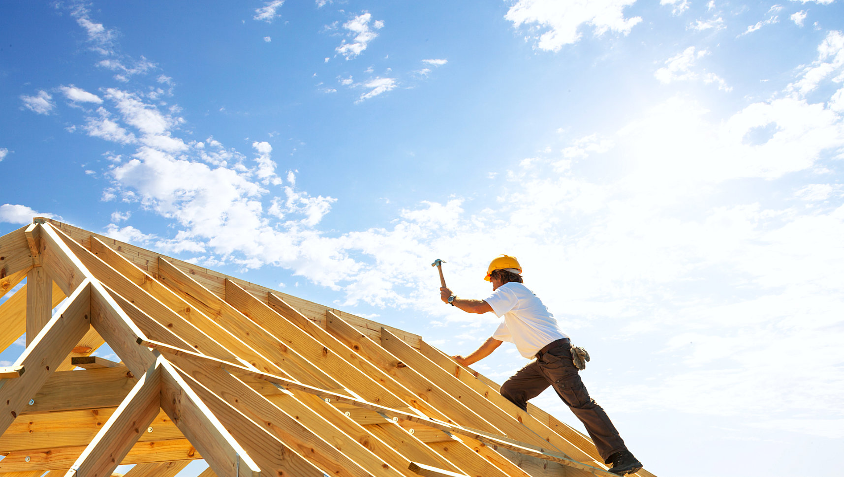 man nailing the part of the unfinished roof top