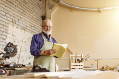 kind grandpa is looking at the camera in the workshop